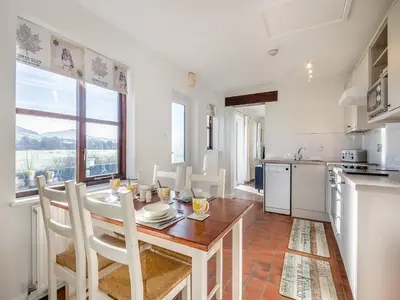 a kitchen and dining room with a table and chairs at Beacons Cottage-Uk36406 in Bronllys