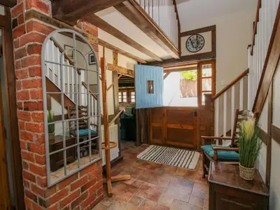 a hallway with a brick wall and a clock at 46-47 Lydbury North in North Lydbury