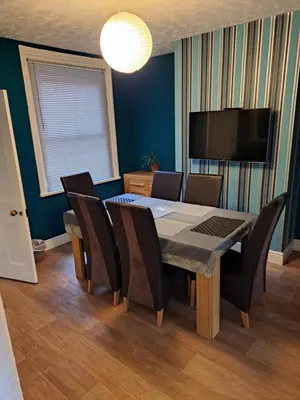 a dining room with a table and chairs and a television at Entire town house with free parking in Oswestry