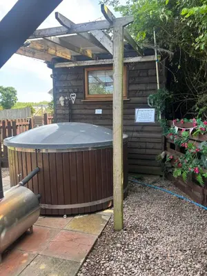 a hot tub in a garden with a pergola at Four seasons with wood fuel hot tub Country retreat in Hereford