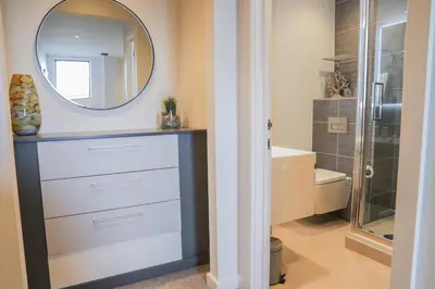 a bathroom with a dresser and a mirror at Apartment Seven in Shrewsbury