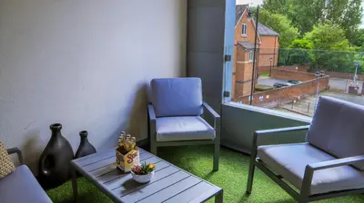 a balcony with two chairs and a table and a window at Apartment Seven in Shrewsbury
