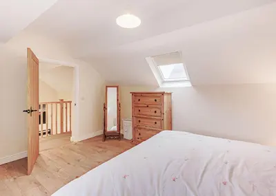 a bedroom with a bed and a skylight at Sgubor Fach in Pen-y-bont-fawr