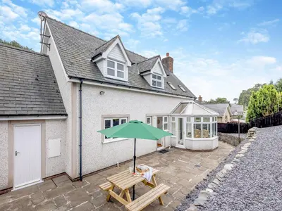 a house with a picnic table and an umbrella at Cysgod Y Capel in Cerrigydrudion