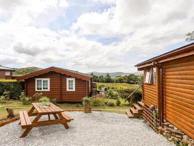 a picnic table in front of a cabin at Ty Coed - 63 in Trawsfynydd