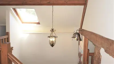 a light fixture hanging from a ceiling in a room at Shepherd's Watch Cottage - 5* Cyfie Farm with private hot tub in Llanfyllin