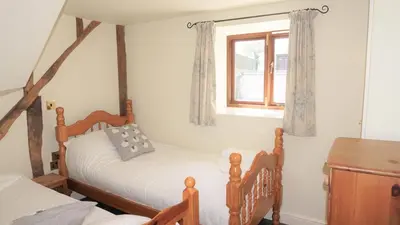 a bedroom with two beds and a window at Shepherd's Watch Cottage - 5* Cyfie Farm with private hot tub in Llanfyllin