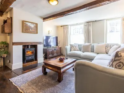 a living room with a couch and a fireplace at Turford House in Ludlow
