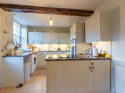 a kitchen with white cabinets and a counter top at Turford House in Ludlow