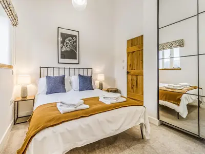 a bedroom with a large bed and a mirror at Mouse Croft - Uk33954 in Llanymynech