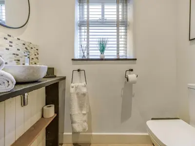 a bathroom with a sink and a toilet and a window at Mouse Croft - Uk33954 in Llanymynech