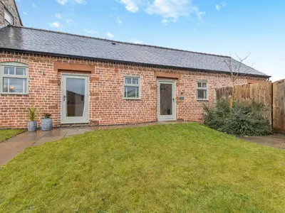 a brick house with a lawn in front of it at Mouse Croft - Uk33954 in Llanymynech