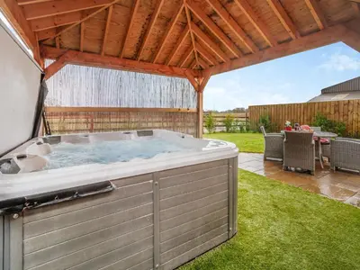 a hot tub in a backyard with a wooden roof at Pheasants Folly - Uk33955 in Llanymynech