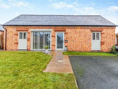 a red brick house with a driveway in front of it at Pheasants Folly - Uk33955 in Llanymynech