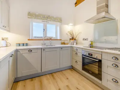 a kitchen with white cabinets and a sink and a window at Pheasants Folly - Uk33955 in Llanymynech