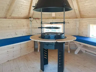 a room with a stove in a wooden cabin at Colstey Farmhouse in Acton