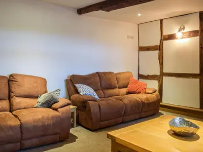 a living room with a couch and a table at Colstey Farmhouse in Acton