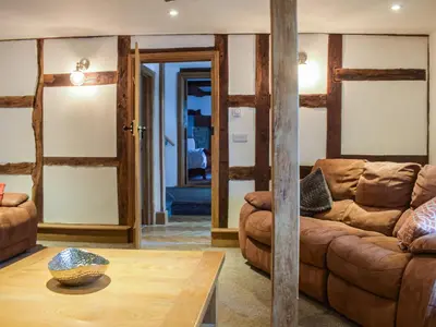 a living room with a couch and a table at Colstey Farmhouse in Acton
