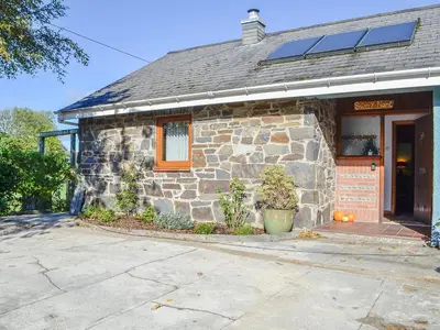 a stone building with a window and a door at Swn Y Nant in Pontrhydfendigaid