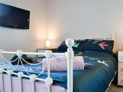 a bedroom with a bed and a tv at Swn Y Nant in Pontrhydfendigaid