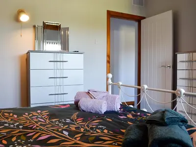 a bedroom with a bed and a dresser at Swn Y Nant in Pontrhydfendigaid