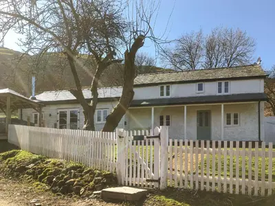 a white picket fence in front of a white house at Middle Hanter - Uk37355 in Old Radnor