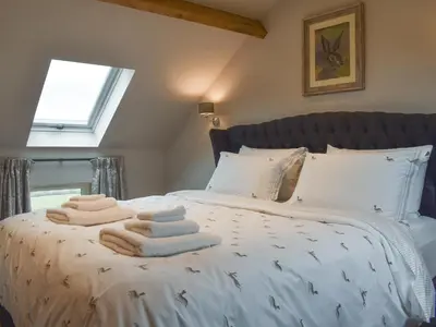 a bedroom with a bed with towels on it at The Shippon in Gwyddelwern