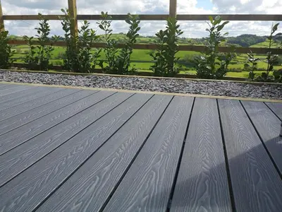 a wooden deck with a view of a field at The Shippon in Gwyddelwern
