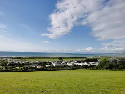a view of a small town with a green field at Sea and Mountain view Sunbeach Holiday Snowdonia in Llwyngwril