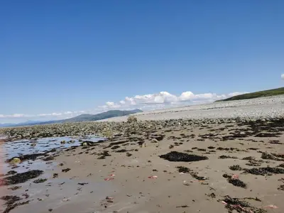 a beach with a lot of trash on it at Sea and Mountain view Sunbeach Holiday Snowdonia in Llwyngwril