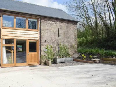 a brick house with a wooden door and some plants at Horsecroft - Uk37462 in Dorstone