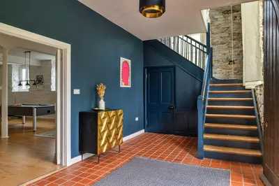 a hallway with blue walls and a blue staircase at Finest Retreats - Luxury Converted Chapel with Hot Tub & Games Room in Dinas Mawddwy