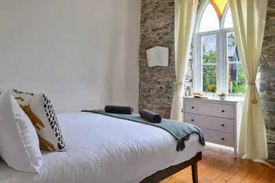 a bedroom with a bed and a window at Finest Retreats - Luxury Converted Chapel with Hot Tub & Games Room in Dinas Mawddwy