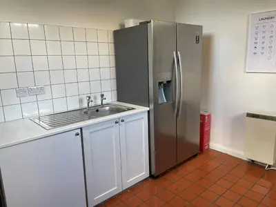 a kitchen with a stainless steel refrigerator and a sink at Finest Retreats - Luxury Converted Chapel with Hot Tub & Games Room in Dinas Mawddwy
