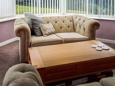 a living room with a couch and a coffee table at Tyglyn Cottage in Lampeter