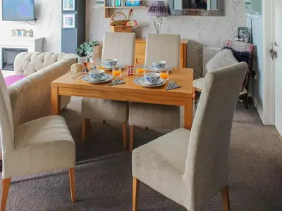 a dining room table and chairs with a meal on it at Tyglyn Cottage in Lampeter