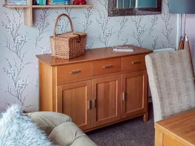 a wooden cabinet with a basket on top of it at Tyglyn Cottage in Lampeter