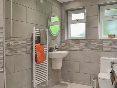 a bathroom with a sink and a toilet and a mirror at Tyglyn Cottage in Lampeter