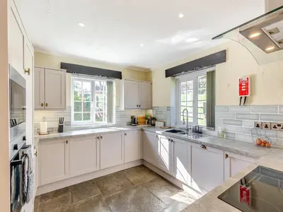 a large white kitchen with white cabinets and windows at The Cottage-Uk37339 in Montgomery