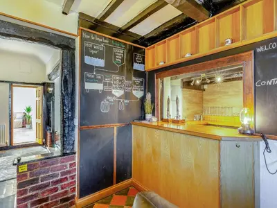 a bar in a restaurant with a sign on the wall at The Cottage-Uk37339 in Montgomery