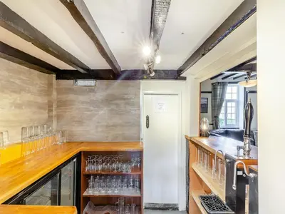a room with a bar with glasses on the counter at The Cottage-Uk37339 in Montgomery