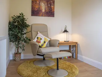 a chair in a room with a table and a plant at The Lookout - Uk35022 in Hope under Dinmore