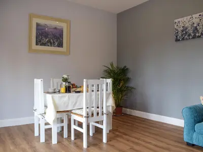 a white dining room with a table and chairs at The Lookout - Uk35022 in Hope under Dinmore