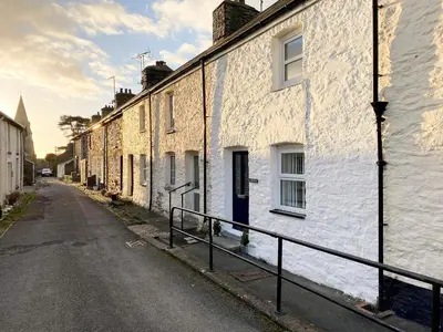 a row of white houses on an empty street at Y Bwthyn in Llanrhystyd