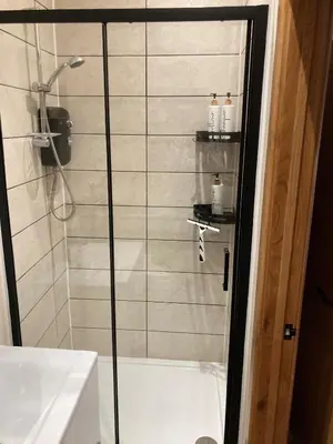 a shower with a glass door in a bathroom at Mini haven in Oswestry
