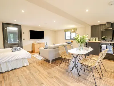 a bedroom with a bed and a table and chairs at The Cabin at Evelyns Retreat in Corwen