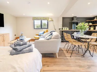 a living room with two beds and a table and chairs at The Cabin at Evelyns Retreat in Corwen