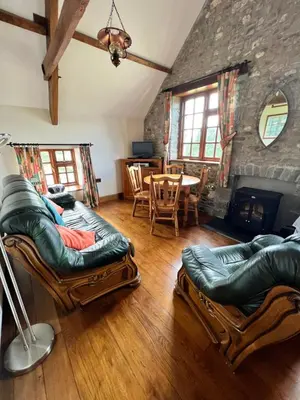 a living room with two couches and a fireplace at Cwmgwn Farm in Llandovery