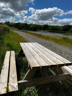 a wooden picnic table sitting on the side of a road at Cwmgwn Farm in Llandovery