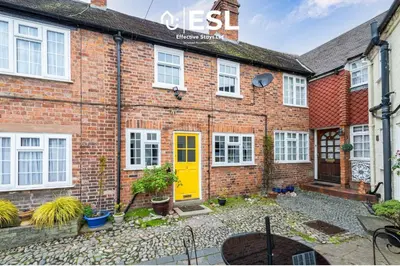 a brick house with a yellow door in front of it at Town Centre Cosy 1 Bedroom Cottage in the Heart of Shrewsbury in Shrewsbury